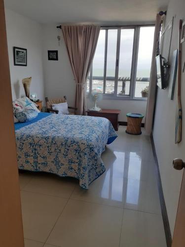 a bedroom with a bed and a large window at Amarras Reales in Piriápolis