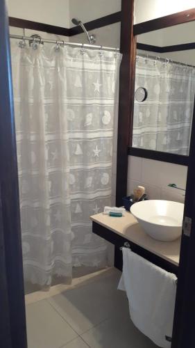 a bathroom with a white shower curtain and a sink at Amarras Reales in Piriápolis