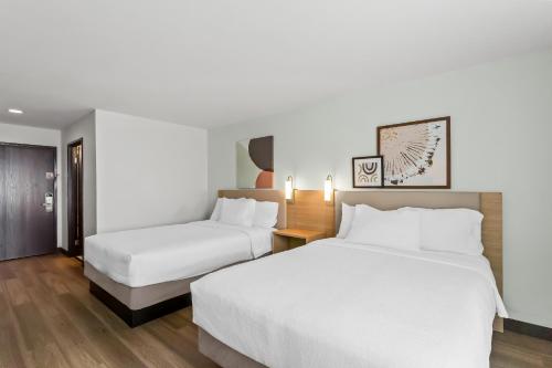 two beds in a hotel room with white sheets at Spark By Hilton Oak Forest I-57 in Oak Forest