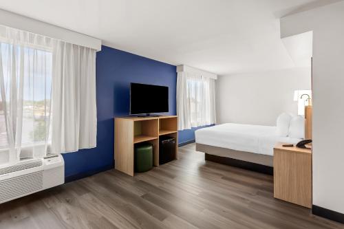 a hotel room with a bed and a tv at Spark By Hilton Oak Forest I-57 in Oak Forest