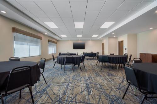 a conference room with tables and chairs and a screen at Holiday Inn Express & Suites Muskegon - Grand Haven by IHG in Muskegon