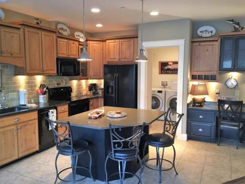a kitchen with a island with chairs and a black refrigerator at Riverfront Condo With Balcony, King Bed Str#267 in Salida