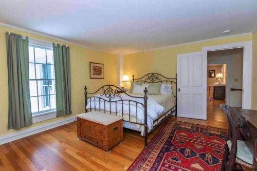 Un dormitorio con una cama y una ventana grande. en Picture Postcard Mansion In Manchester Village, en Manchester