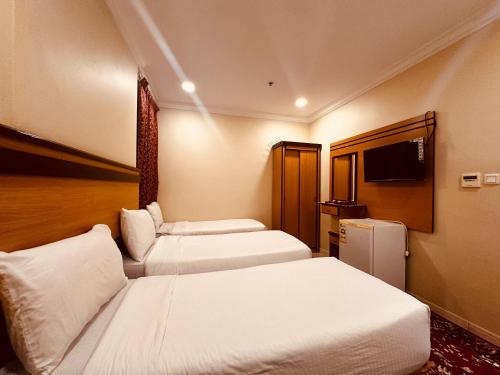 a hotel room with two beds and a television at فندق الرسالة رويال in An Naqāʼ