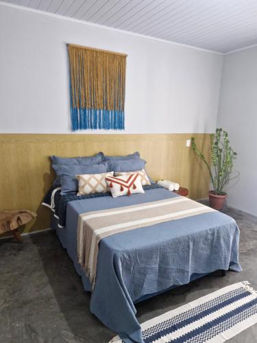 a bedroom with a bed with blue sheets and a window at Ranch Dias Atins in Atins