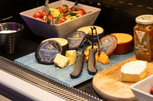 a table with cheese and other foods on a counter at Moxy York in York