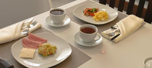 einen Tisch mit zwei Teller Essen und zwei Tassen Kaffee in der Unterkunft Hospedaje Turístico - Kantu Inn in Ollantaytambo