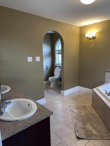 a bathroom with a sink and a toilet in it at 4- Bedroom Modern Townhouse in Halifax