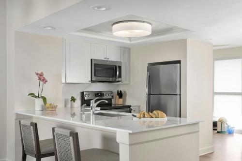 a kitchen with white cabinets and a stainless steel refrigerator at Marriott's Harbour Point and Sunset Pointe at Shelter Cove in Hilton Head Island