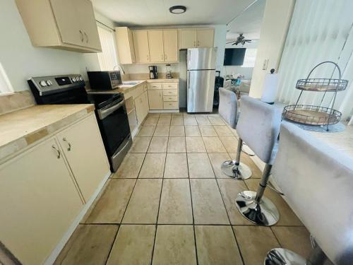 a kitchen with white cabinets and a tiled floor at Cozy Pool-House with 3 bedrooms-2 bathrooms in Margate