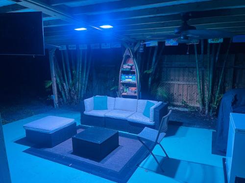 a living room with a couch and ottoman in the dark at Cozy Pool-House with 3 bedrooms-2 bathrooms in Margate