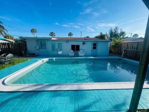 a swimming pool in front of a house at Cozy Pool-House with 3 bedrooms-2 bathrooms in Margate