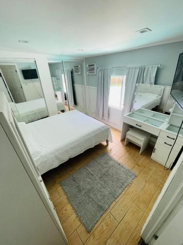 a bedroom with a white bed and a mirror at Cozy Pool-House with 3 bedrooms-2 bathrooms in Margate