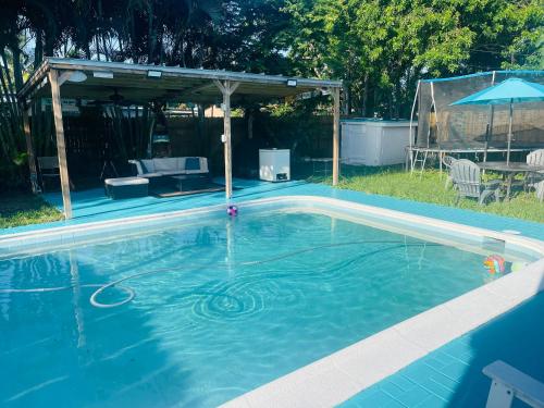 a swimming pool with a gazebo in a yard at Cozy Pool-House with 3 bedrooms-2 bathrooms in Margate