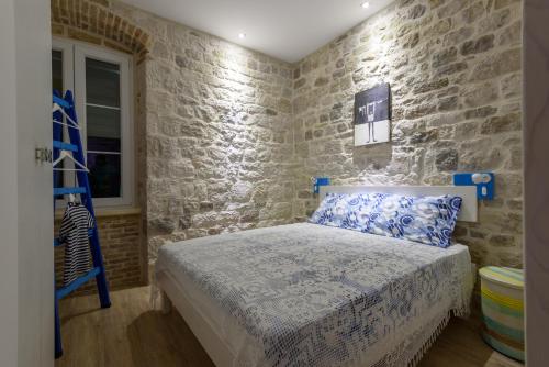 a bedroom with a bed and a blue ladder at Apartments Kaja in Trogir