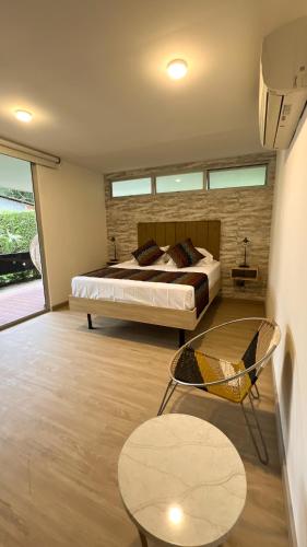 a bedroom with a bed and a chair and a table at Casa Turística Don Juan in Ibagué