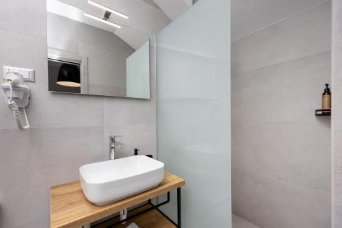 a bathroom with a white sink and a mirror at Hotel - Teranea City Hvar in Hvar