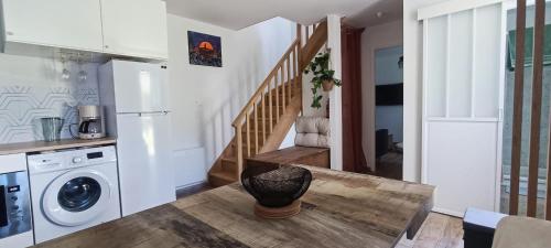 eine Küche mit einem Tisch und einer Waschmaschine in der Unterkunft Le Ptit Cottage in Landivisiau
