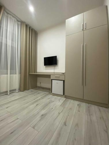 an empty room with a desk with a television and a cabinet at Hotel U Radnice Aš in Aš