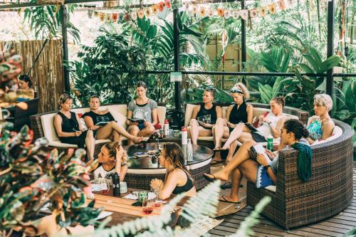 a group of people sitting in chairs in a garden at Danyasa Eco-Retreat in Dominical