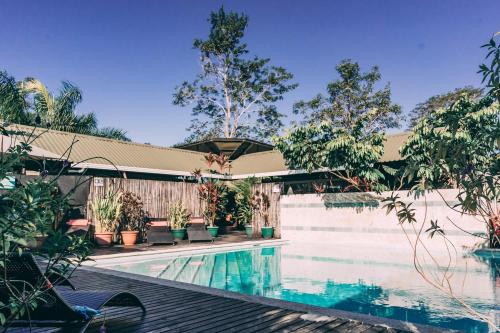 a swimming pool next to a fence with trees at Danyasa Eco-Retreat in Dominical