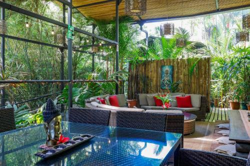 an outdoor patio with a glass table and chairs at Danyasa Eco-Retreat in Dominical
