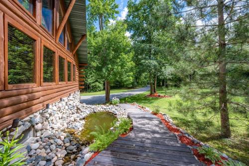 a wooden walkway next to a house at The Hideaway On Little Jay Log Home in Cohasset