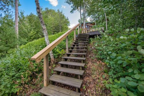 a wooden staircase leading up to a forest at The Hideaway On Little Jay Log Home in Cohasset