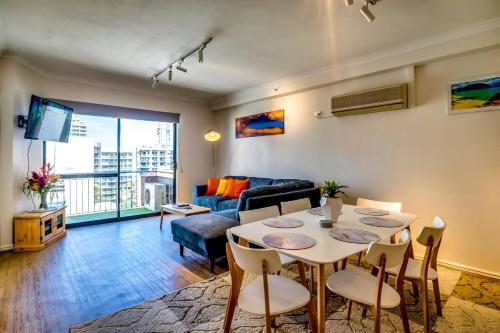 una sala de estar con una mesa y un sofá en 60 Sparkling Perth East End Poolparking, en Perth