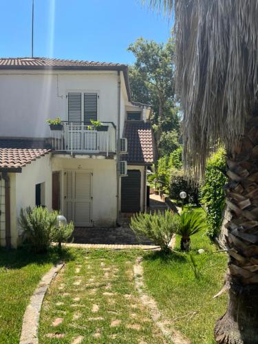a white house with a balcony and a yard at Clorofilla - Country House in Francavilla Angitola