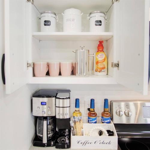 a kitchen cabinet with bottles of alcohol and a coffee maker at Pets Ok! Heated Pool Mins To 3 Sisters Spring! in Crystal River