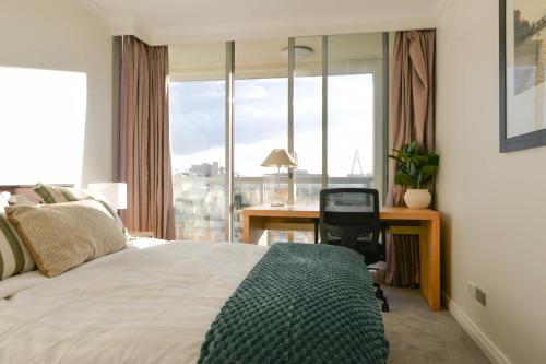 a bedroom with a bed and a desk with a window at Harbour Home 2BR Apt - Family Friendly Gem in Sydney