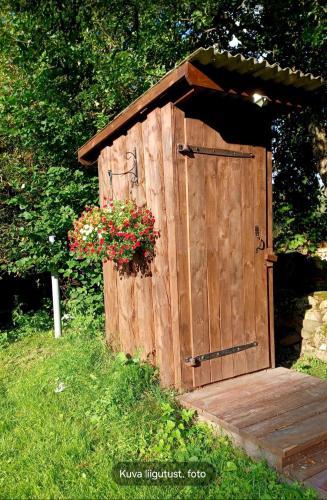 a wooden out house with a flower pot on it at Tammiku saunamaja 