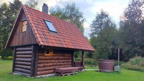 a small log cabin with a red roof at Tammiku saunamaja 
