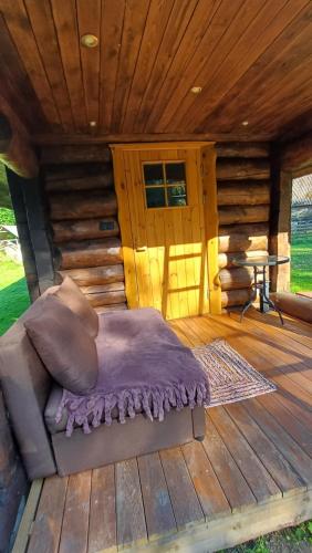 a bed on the deck of a log cabin at Tammiku saunamaja 