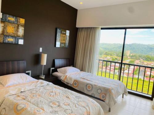 a hotel room with two beds and a large window at Stunning 9th Flr Pacific Ocean And Mtn View in Jacó