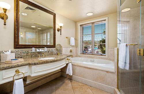 a bathroom with a tub and a large mirror at Carlton Hotel in Atascadero