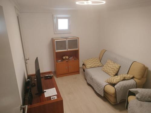 a living room with a couch and a tv at Casa São Miguel T2 in Serpa