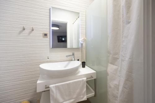 a white bathroom with a sink and a mirror at Hotel - Teranea City Hvar in Hvar