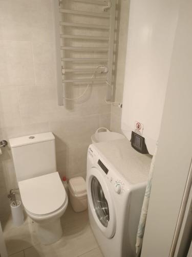 a bathroom with a toilet and a washing machine at Casa São Miguel T2 in Serpa