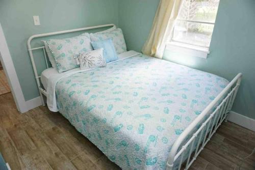 Bett in einem Schlafzimmer mit blauer Wand in der Unterkunft Beachside Cottage Walk 2BeachOcean Center PETS OK in Daytona Beach