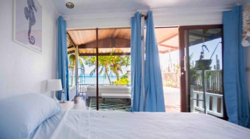 a bedroom with a bed and a view of the ocean at Sunset Dream Beach Front House in Thong Sala