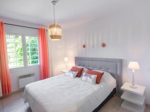 - une chambre avec un grand lit et des rideaux rouges dans l'établissement Les Romarins, à Saint-Tropez