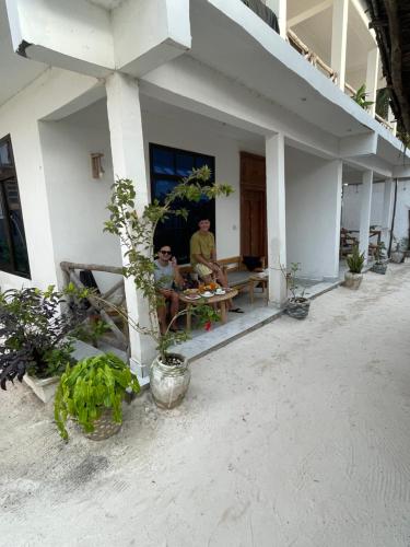 two people sitting at a table outside of a house at Zanzibar beach escape 1&2 in Bwejuu