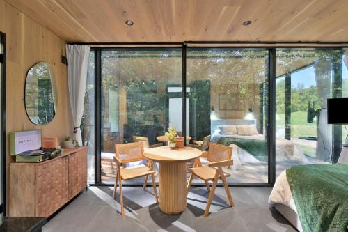 a room with a bed and a table and chairs at Mirror Cabin & Sauna In A Forest in Coldspring