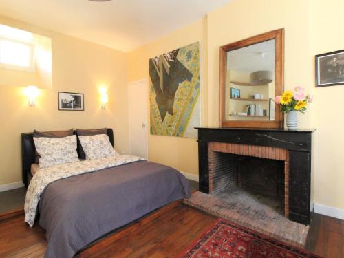 - une chambre avec un lit, une cheminée et un miroir dans l'établissement Charmant Appartement Central à Angers - Tout Inclus, Wifi, Proche Gare et Patrimoine - FR-1-622-6, à Angers