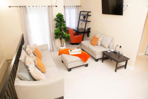 a living room with two couches and a tv at Stacys Place #2 2 Bedroom Apartment in Port-of-Spain