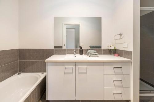 Un baño blanco con bañera, lavabo y bañera Tubermott en Golden Retreat - Couples Getaway Business stay, en Golden Square