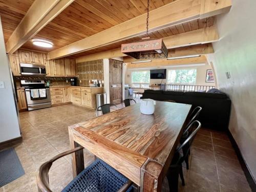 a kitchen and dining room with a wooden table and chairs at Poncha Creek Mountain Lodge, Near Monarch Mtn in Salida