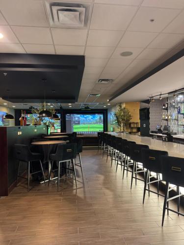 a restaurant with a bar with tables and chairs at Hotel Gurnee in Gurnee